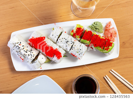 Urumaki roll with salmon avocado pepino and tobiko Urumaki roll with salmon avocado pepino and tobiko 128435563