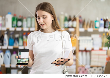 Young woman choosing cosmetics in household chemicals store 128435573