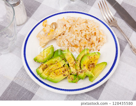 Healthy dinner of basmati rice with chicken breast and avocado 128435580
