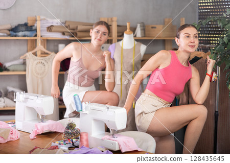 Young and adult women doing warm-up exercises in sewing workshop 128435645