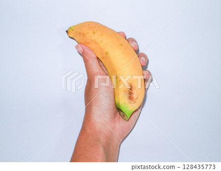 Asian woman holding banana in hand. Tropical fruit, organic nutrition, healthy lifestyle. 128435773