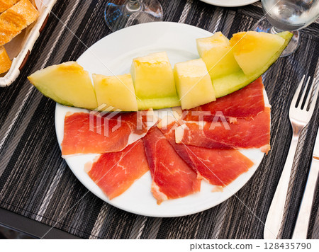 Slices of jamon served with fresh melon - national Spanish snack Slices of jamon served with fresh melon - national Spanish snack 128435790