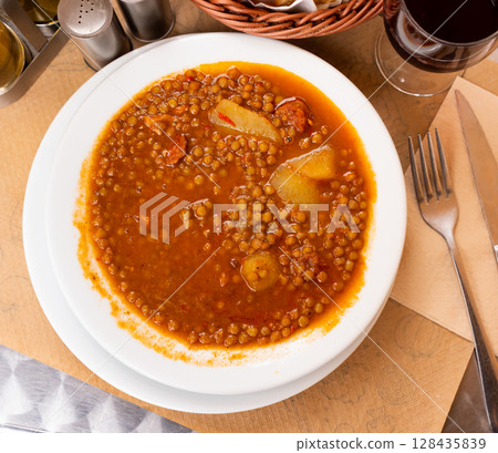 Lentil soup with potatoes and chorrizo sausage. Spanish traditional dish Lentil soup with potatoes and chorrizo sausage. Spanish traditional dish 128435839