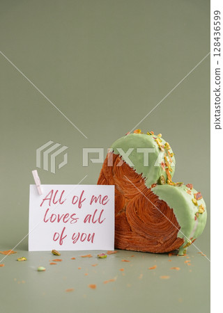 ALL OF ME LOVES ALL OF YOU greeting card note Valentines day celebration idea Heart shaped pistachio croissant on green background with copy space. Puff pastry trendy sweet dessert bakery. Creamy ALL OF ME LOVES ALL OF YOU greeting card note Valentines day celebration idea Heart shaped pistachio croissant on green background with copy space. Puff pastry trendy sweet dessert bakery. Creamy 128436599