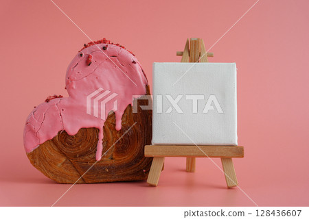 Empty paper note template sample mock up blank for wishes greeting holiday card Heartshaped pastry croissant treat topped with colorful frosting galore. Food experimentation viral dessert baking trend 128436607