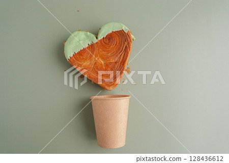 Craft paper cup Delightful and vibrant heartshaped pastry croissant treat, beautifully topped with colorful frosting nut galore. Mock up template copy space. Food experimentation viral dessert Craft paper cup Delightful and vibrant heartshaped pastry croissant treat, beautifully topped with colorful frosting nut galore. Mock up template copy space. Food experimentation viral dessert 128436612