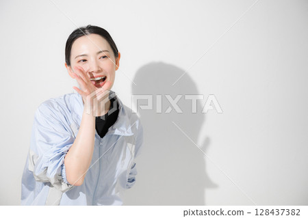 A woman in sportswear cheering, looking at the camera, smiling A woman in sportswear cheering, looking at the camera, smiling 128437382