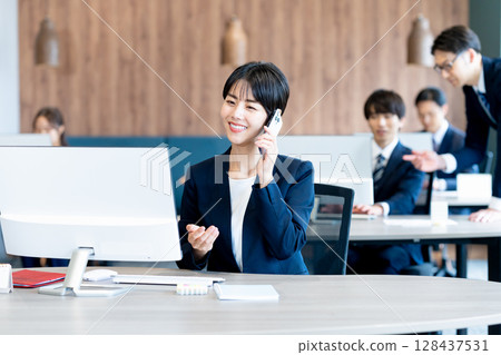 Business woman using a smartphone in the office Business woman using a smartphone in the office 128437531