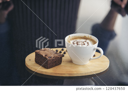 Latte art coffee cup with milk on wooden table. Espresso shot make latte art hot coffee cup. Cappuccino with milk in italian coffee shop cafe. Brown hot caffeine beverage in cafeteria with copy space 128437650