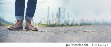 Men wear construction Boots safety footwear for worker at construction site. Engineer Wear Jeans Brown Boots Worker on Background of Refinery. Engineer safety industry fashion footwear walking outdoor Men wear construction Boots safety footwear for worker at construction site. Engineer Wear Jeans Brown Boots Worker on Background of Refinery. Engineer safety industry fashion footwear walking outdoor 128437673