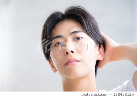 男人撫摸他的黑髮，特寫，護髮圖像，嚴肅而認真的表情 128438120