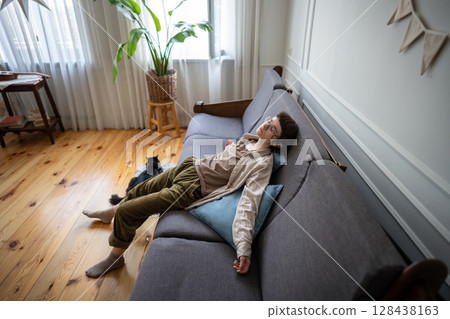 Tired lazy woman lying on sofa and looking up, bored and apathetic female and cat in isolation Tired lazy woman lying on sofa and looking up, bored and apathetic female and cat in isolation 128438163