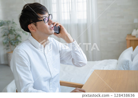 A man who uses a smartphone A man who uses a smartphone 128438636