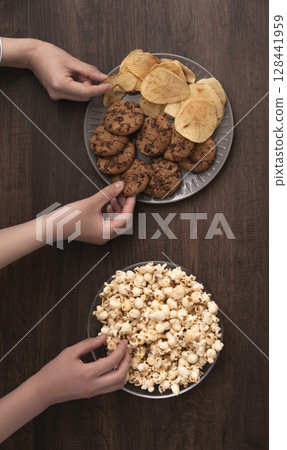 Family and friends eating snacks and sweets 128441959