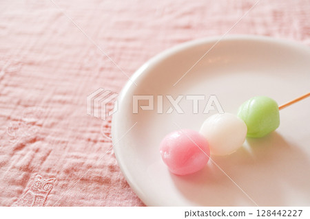 Three-colored dumplings on a white plate 128442227