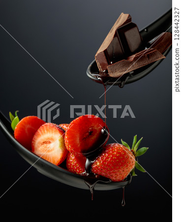 Fresh strawberries and melted dark chocolate. 128442327
