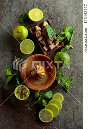Wooden citrus squeezer and ingredients for making summer refreshing drinks. 128442337