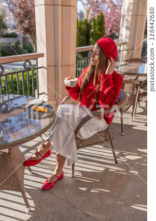 Woman Coffee Beret: Sunny morning, stylish woman enjoys coffee & pastry on cafe patio. Woman Coffee Beret: Sunny morning, stylish woman enjoys coffee & pastry on cafe patio. 128442680