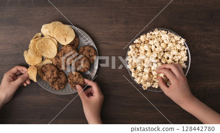 Family and friends eating snacks and sweets Family and friends eating snacks and sweets 128442780