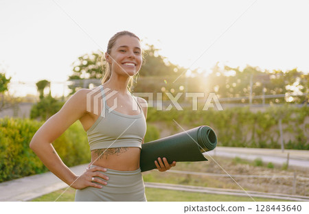 An Energetic Fitness Enthusiast Holding a Yoga Mat at Beautiful Sunrise, Embracing Health 128443640