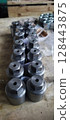 Metal components with a hexagonal head. Industrial fasteners on a wooden surface. Mechanical engineering. Is used in such fields as mechanical engineering, oil and gas, metallurgy, chemical.  128443875