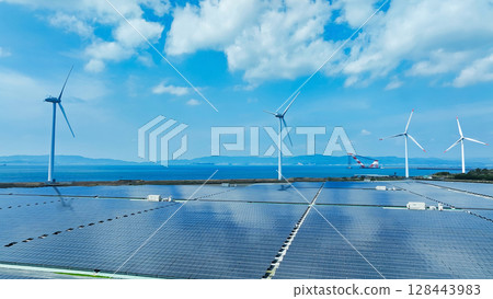 Aerial view of a hybrid power plant with wind turbines and solar panels Aerial view of a hybrid power plant with wind turbines and solar panels 128443983
