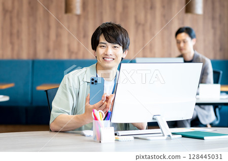 A businessman who uses a smartphone in the office 128445031