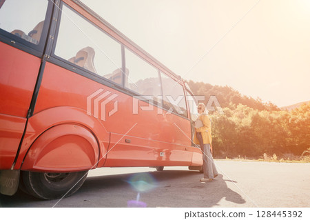 Bus, Mountains, Travel: People getting off a red bus in a scenic mountainous area for a travel adventure. Bus, Mountains, Travel: People getting off a red bus in a scenic mountainous area for a travel adventure. 128445392