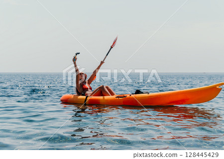 Woman Kayaking Ocean Selfie - A woman takes a selfie while kayaking on the ocean. 128445429