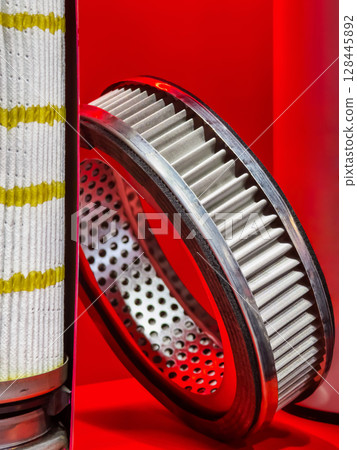 Close-up view of air and oil filters showcasing intricate designs and materials in a vibrant setting 128445892