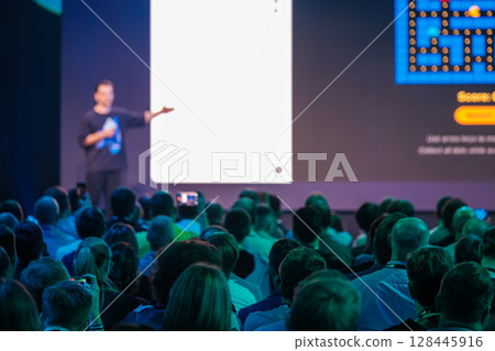 Speaker addressing audience at technology event with multimedia presentation Speaker addressing audience at technology event with multimedia presentation 128445916