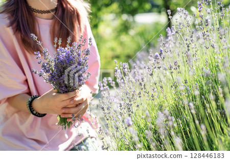 Woman holding lavender bouquet in blooming field Woman holding lavender bouquet in blooming field 128446183