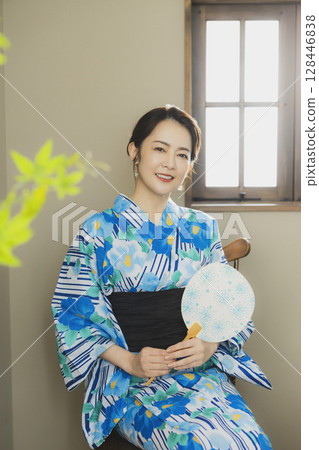 A woman in a yukata by the window A woman in a yukata by the window 128446838