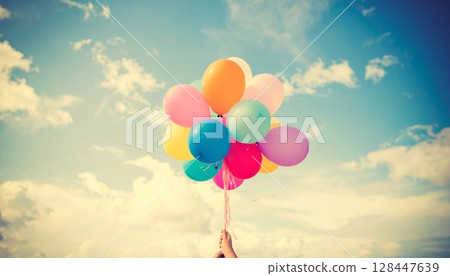 Colorful balloons fly with joy in the blue sky above a summer beach celebration Colorful balloons fly with joy in the blue sky above a summer beach celebration 128447639