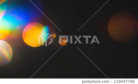 A glowing blue lens flare from a digital film projector shines through the dark night sky, creating a bright, artistic effect A glowing blue lens flare from a digital film projector shines through the dark night sky, creating a bright, artistic effect 128447786