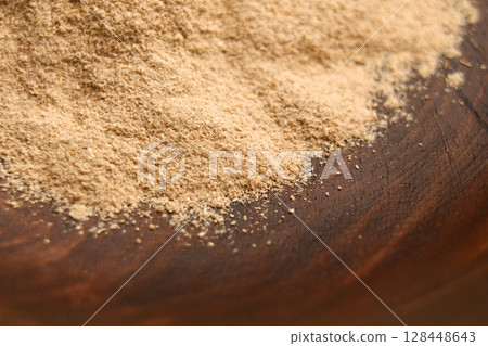 Ayurvedic Ashwagandha root powder in wooden bowl. Calming anti-stress supplement.  128448643