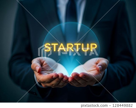 Business professional holds glowing startup label in hands, symbolizing innovation and entrepreneurship 128449882