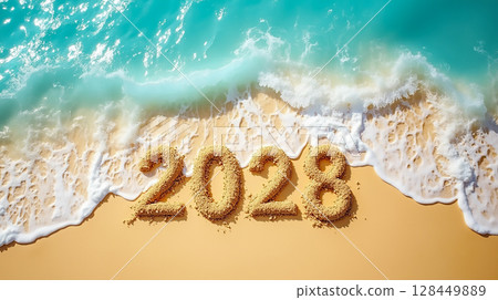 Sand numbers carved on a beach represent the upcoming year 2028 with waves gently touching the shore 128449889