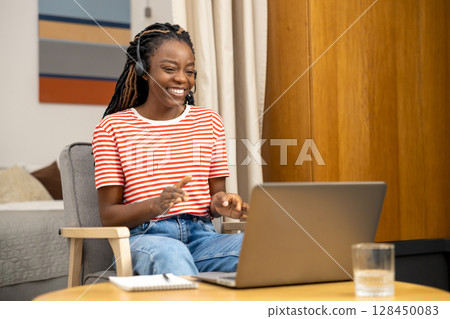 Contented young woman having a talk online and looking happy and excited Contented young woman having a talk online and looking happy and excited 128450083