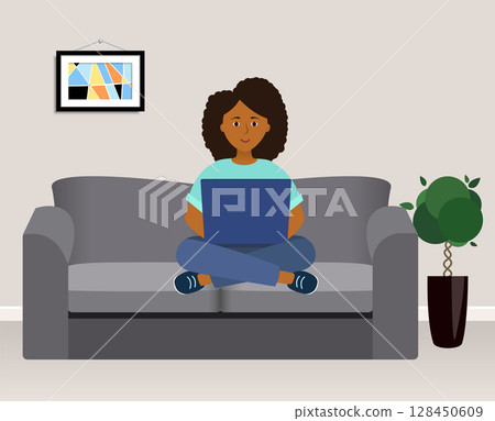 Woman with laptop. Works at home, sits on the couch. Cozy house. African woman. 128450609