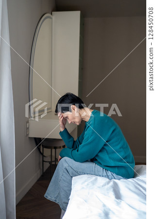 Depressed subdued woman in grief sorrow sit on bed head down. Sleep disorder, social fear isolation 128450708