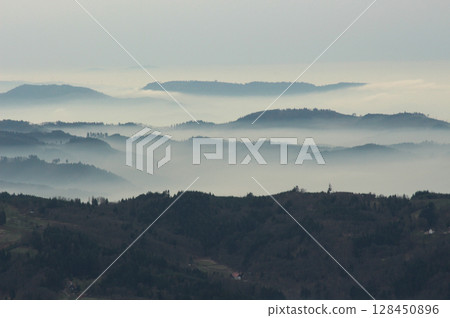 a mysterious landscape of mountains shrouded in fog and towering over the Mummelsee in Germany a mysterious landscape of mountains shrouded in fog and towering over the Mummelsee in Germany 128450896