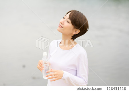 Woman hydrating in the park Woman hydrating in the park 128451518