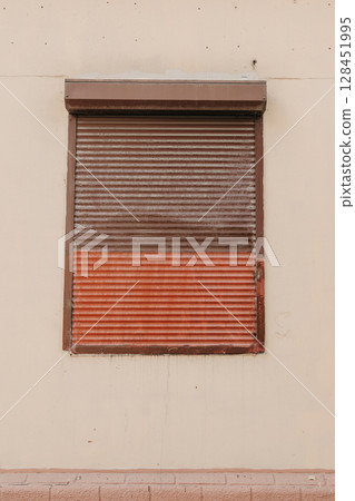 Red brown metal roller window with horizontal lines. Old window. Red brown metal roller window with horizontal lines. Old window. 128451995