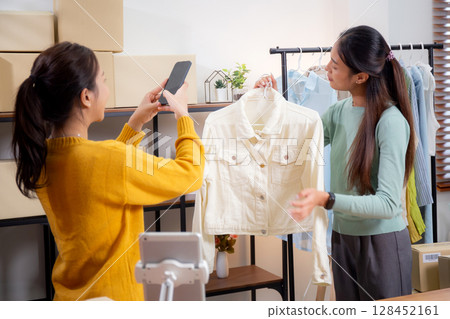 Two asian woman taking picture of clothes for online store, woman collaboration with online seller. 128452161