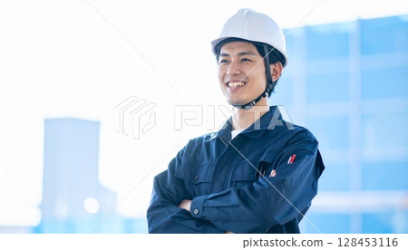 Young worker wearing a helmet at a construction site 128453116