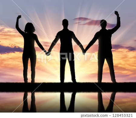 Silhouette of a group of happy people of three people holding hands 128453321