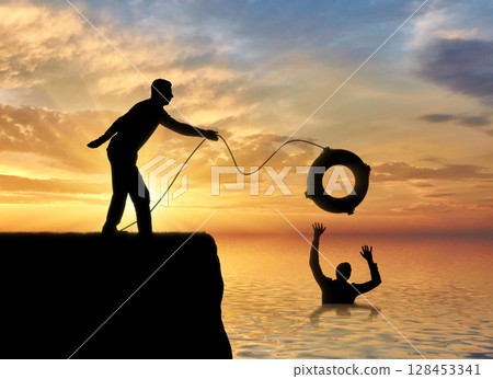 A silhouette of a man throws a lifeline to another man who is drowning in the water A silhouette of a man throws a lifeline to another man who is drowning in the water 128453341
