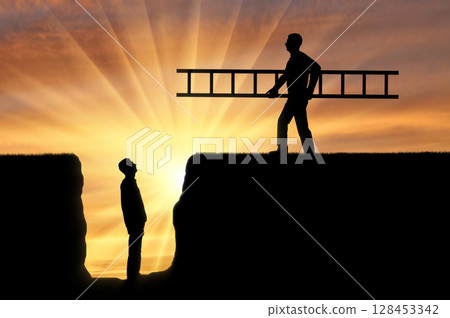 A silhouette of a man carries a ladder to another man who is in a pit 128453342