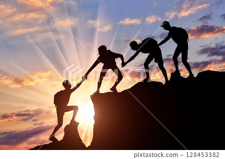 Men climbers help each other in the mountains Men climbers help each other in the mountains 128453382